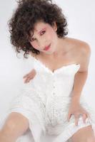 Beautiful young green eyed woman in white corset smiles and looks at the camera. Beauty concept photo