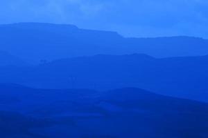 paisaje de verano de las montañas con degradado de colores azules de los picos de las montañas, fondo al aire libre de viajes de naturaleza. foto