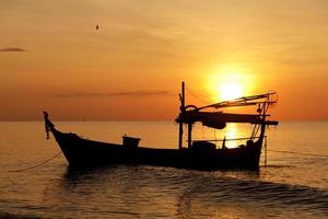 Silhouette of fishing boat at sunset photo