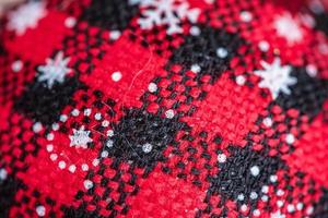 The texture of the Christmas toys macro photo close-up. Christmas red black and white ornament.