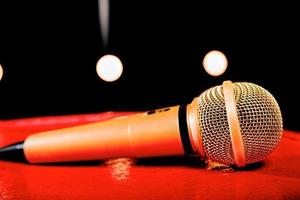 gold microphone on red wooden and dark backgrounds with many lights photo