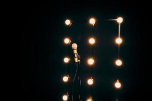 gold microphone on microphone stand on dark background with many lights photo