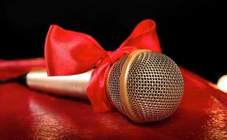 gold microphone on red wooden and dark backgrounds with many lights