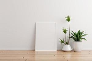 Maqueta de marco de fotos vertical blanco en una habitación vacía de pared blanca con plantas en un piso de madera