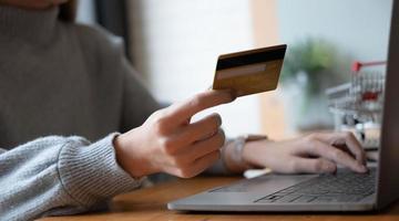 Online payment,Young woman's hands using computer and hand holding credit card for online shopping photo
