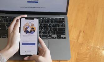 A working from home employee is downloading the Microsoft Teams social platform, ready for remote working in isolation from home photo