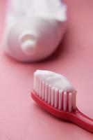 tooth brush and paste on pink photo