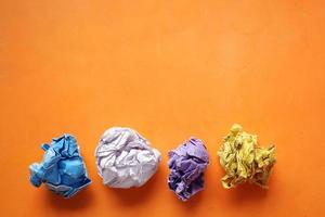 top view of crumpled paper balls on orange background photo