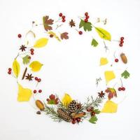Wreath made of autumn flowers and leaves on white isolated background photo