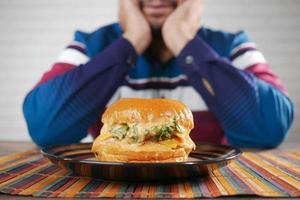 hungry man waiting for eating beef burger on table close up photo