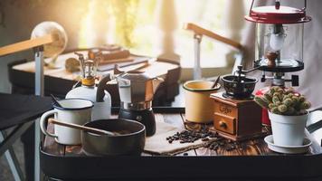 taza de café, granos tostados e ingredientes para hacer café y accesorios en la mesa. concepto de fabricación de café foto