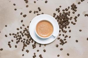 Cup of coffee cappuccino with coffee beans on a table vintage background photo
