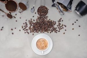 Fondo con café surtido, granos de café, taza de café negro, equipo de cafetera