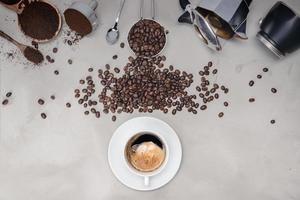 Fondo con café surtido, granos de café, taza de café negro, equipo de cafetera