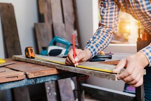 Carpenter working on woodworking machines in carpentry shop. photo