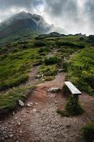wooden bench at the foot of a misty mountain photo