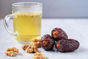 Medjool dates with walnuts and tea on table. Highly nutritious fruit increases breast milk for breastfeeding mothers. Popularly eaten in the month of Ramadan.