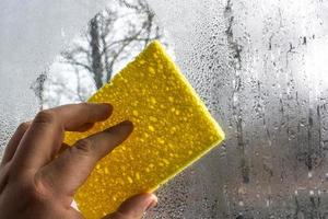 A man wipes a foggy window photo