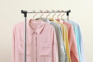 Camisas de mujer en colores pastel colgadas en el estante foto