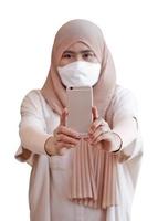 Muslim girl wearing taking a selfie with smartphone on white background photo