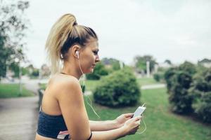 Mujer con auriculares escuchando música en smartphone foto