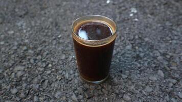 black coffee in a cup placed on asphalt photo