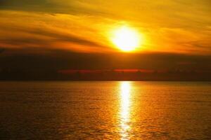 mar y cielo dorado amanecer y pequeños barcos de pesca foto