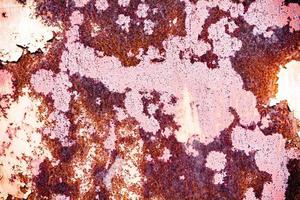 Brown grunge texture of an old metal wall covered in rust. Textured surface with an interesting pattern, dirty sheet metal with peeling paint. Weathered, rough and rust-eaten iron wall of the garage. photo