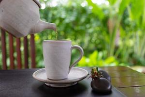 hot tea was poured into tea cup served on table in cafe photo