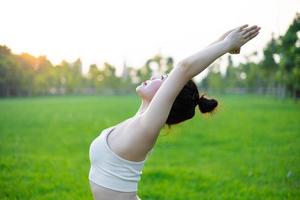 image of asian woman doing yoga outdoors photo