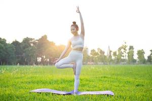 image of asian woman doing yoga outdoors photo