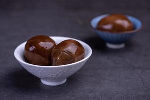 Chinese tea eggs, cut or whole marinated eggs in dark background photo