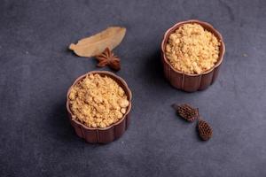 The refined meat floss is in the cup in the dark background photo
