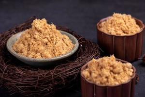 The refined meat floss is in the cup in the dark background photo