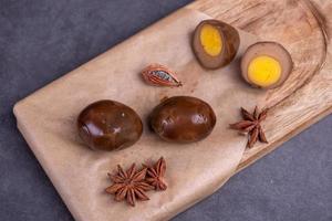 Chinese tea eggs, cut or whole marinated eggs in dark background photo