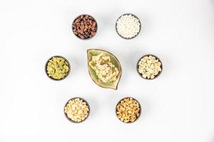 Peanuts, melon seeds, raisins, cashews and walnuts are in a hexagonal shape on a white background photo