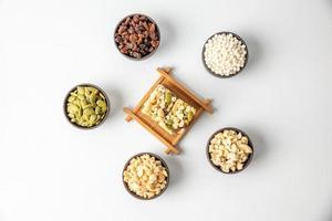 Peanuts, melon seeds, raisins, cashews and walnuts are in a hexagonal shape on a white background photo