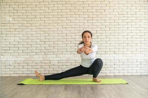 Latin woman practicing yoga on mat photo