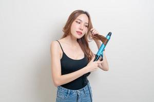 portrait beautiful Asian woman using hair curler or curling iron photo