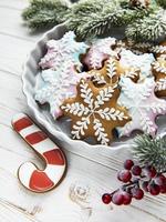 Tazón de galletas de Navidad de jengibre en rústica mesa de madera blanca foto