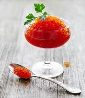 Glass with delicious red caviar photo