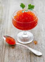 Glass with delicious red caviar photo