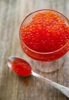 Glass with delicious red caviar photo