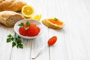 Red caviar in bowl and sandwiches photo