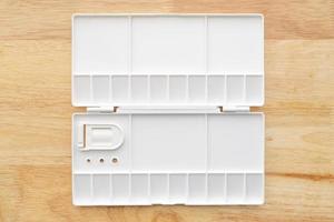 White watercolor palette. Empty watercolor tray isolated on wood background. photo