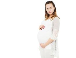 Young beautiful pregnant woman standing on white background isolated photo