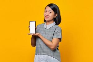 Smiling asian woman showing blank smartphone screen with palm. product promotion concept