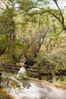 walk of the bride and groom through the autumn forest photo