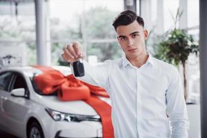 Happy young man with keys in his hands, lucky buy a car photo