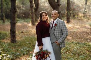 walk of the bride and groom through the autumn forest photo